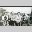 Photograph of people with dogs in front of a car and barracks (ddr-csujad-47-329)