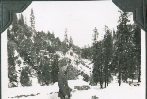 Man standing on road in snow with suitcases (ddr-ajah-2-348)