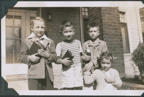 Photo of four children holding book (ddr-densho-483-1239)