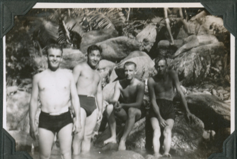 Four men standing in river in swim trunks (ddr-ajah-2-637)