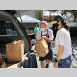 Man and woman loading food bags into car (ddr-densho-512-71)