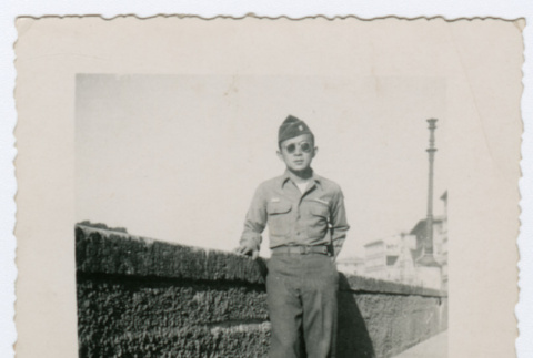 Soldier standing on sidewalk near waterfront (ddr-densho-368-207)