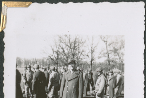 Man in uniform standing in field with others (ddr-densho-434-44)