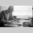 Harry Fukuhara looking through papers (ddr-densho-1007-1167)