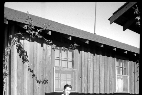 Young man in front of wooden building (ddr-densho-475-136)