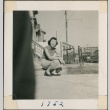 Woman sitting on a curb (ddr-densho-321-112)