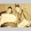 Two sumo wrestlers reading a paper (ddr-njpa-4-2047)