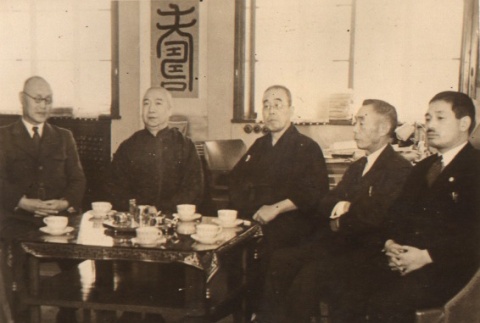 Buddhist priest and others seated around a coffee table (ddr-njpa-4-303)