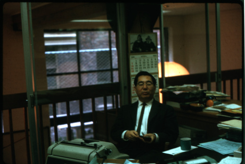 Henri Takahashi seated in office (ddr-densho-426-314)