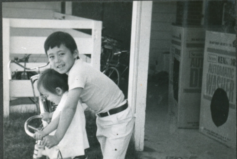 Girl on tricycle with older boy (ddr-densho-523-579)