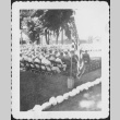 Crowd of men seated, flag in foreground (ddr-densho-434-399)