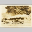 A small tank rolling past smoke from an explosion (ddr-njpa-13-819)