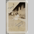 Woman sitting on lawn outside building (ddr-densho-587-65)