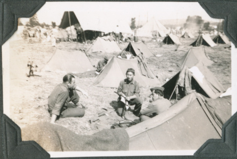 Three men sitting near tents.  Joe Iwataki in center (ddr-ajah-2-258)