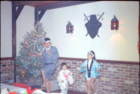 Man and two children performing at party (ddr-densho-426-1174)