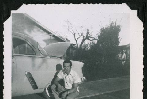 Walter Matsuoka kneels next to a car (ddr-densho-390-95)