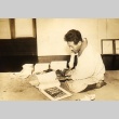 Ryushi Kawabata looking at an art book (ddr-njpa-4-548)