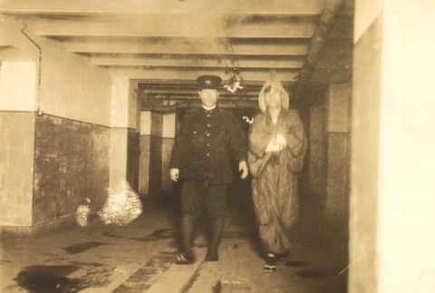 A Japanese naval officer and another man walking in a hallway (ddr-njpa-4-2726)