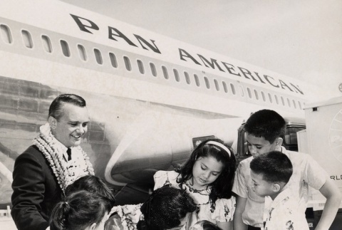 Woman kissing a young boy in front of a Pan American airplane (ddr-njpa-2-41)