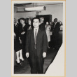 Man in suit, with group in background (ddr-densho-522-85)
