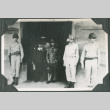 Men standing in doorway with guards on either side (ddr-ajah-2-716)
