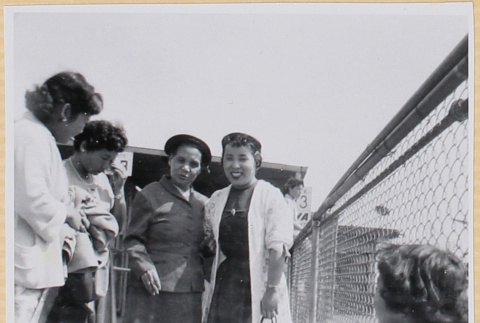 Four women standing on fence (ddr-densho-522-51)