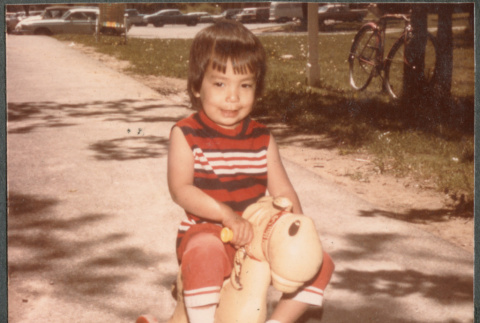 Girl riding toy horse (ddr-densho-523-590)