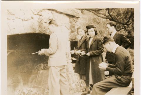 Two women and three men standing by large outside fireplace (ddr-densho-426-1861)