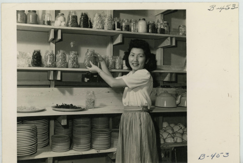 Mary Sakai in a pantry store room (ddr-densho-37-2163)