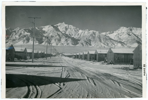 Photograph of snow-covered Manzanar street with barracks on both sides (ddr-csujad-47-53)