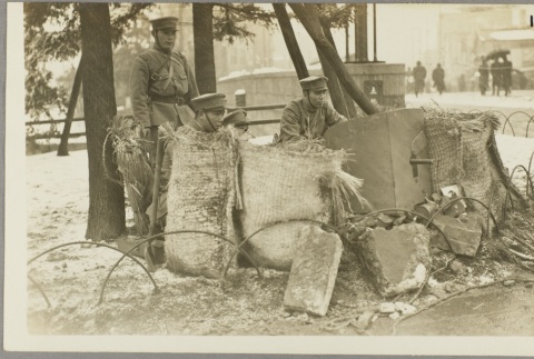 Soldiers crouched behind a protective barrier (ddr-njpa-13-1410)