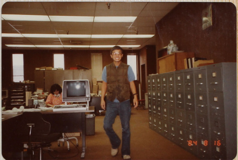 Man walking past file cabinets in office (ddr-densho-426-1352)
