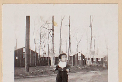 Todd Endo walking down road by barracks at Rohwer Relocation Center (ddr-densho-379-679)