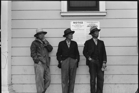 Three men standing in front of posted exclusion orders (ddr-densho-151-83)
