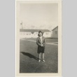 Woman standing outside camp administration buildings (ddr-manz-7-45)