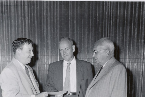 Sears executive giving a check to a University of Hawaii president and dean (ddr-njpa-2-1011)