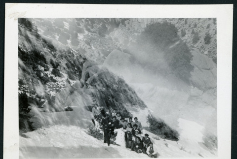 Photograph of a group of people holding snow balls on the side of a mountain with a snowman (ddr-csujad-47-295)