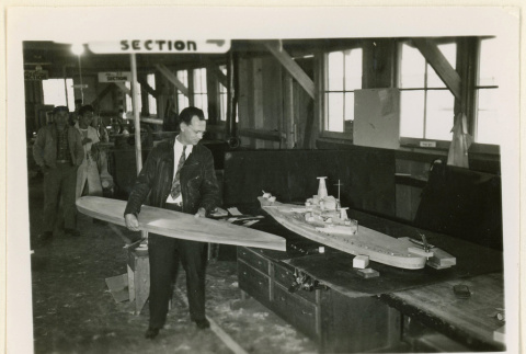 Mr. Martin holds a model hull (ddr-densho-37-1354)
