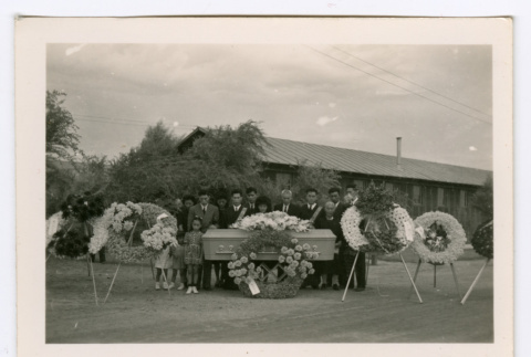 Small group of funeral attendees with casket (ddr-densho-475-298)