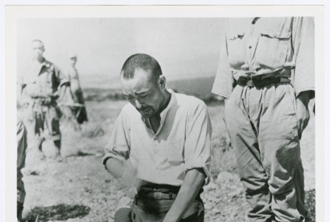 Japanese POW kneeling at a grave (ddr-densho-1007-281)