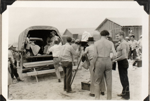 Men filming people climbing into back of truck (ddr-densho-587-81)