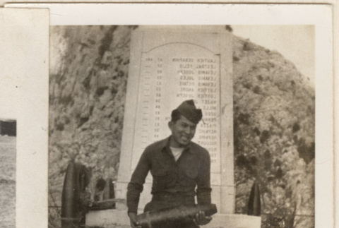 Man holding mortar shell in front of memorial (ddr-densho-466-252)