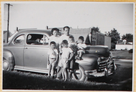 Family standing next to car (ddr-densho-522-69)