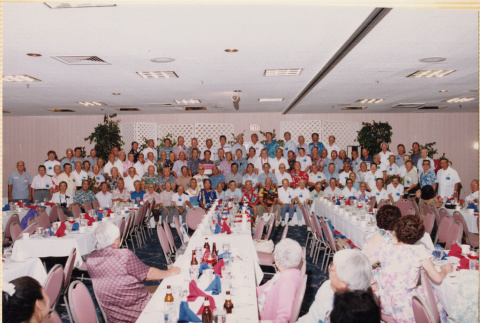 Large group photo of veterans standing with banquet table in foreground (ddr-densho-466-513)