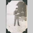 Man reading outside camp building in snow (ddr-ajah-2-464)