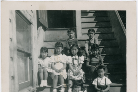 Group of children sitting on stairs (ddr-densho-426-987)