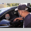Man talking to woman inside car (ddr-densho-512-78)