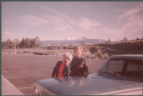 Two women next to car in parking lot (ddr-densho-523-607)