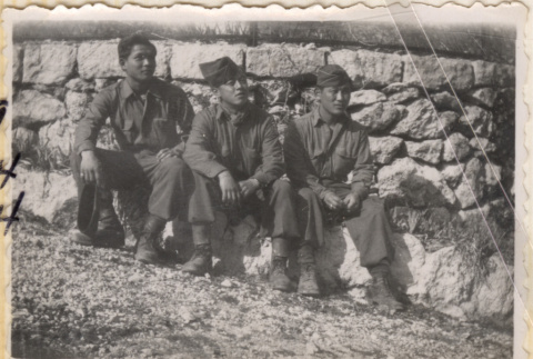 Three soldiers sitting by stone wall (ddr-densho-466-247)