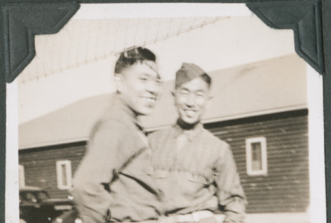 Two men standing outside camp buildings (ddr-ajah-2-484)